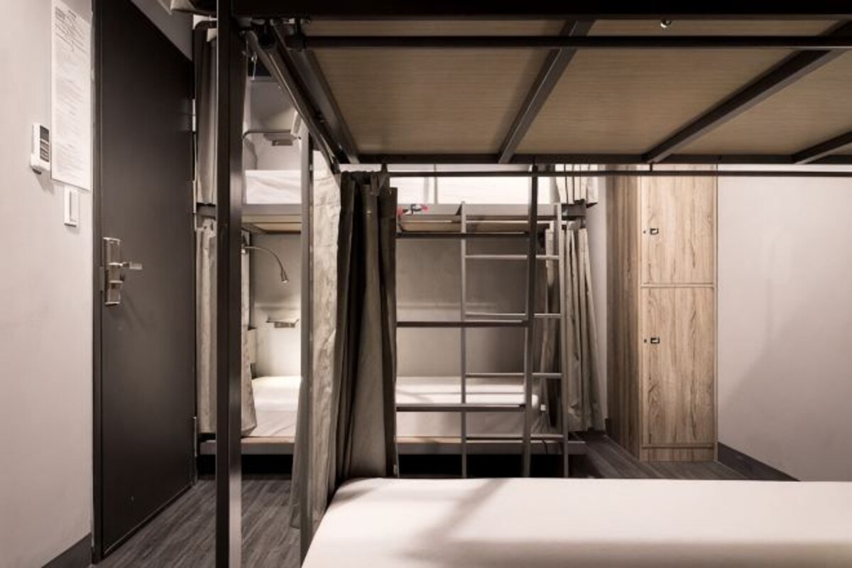A compact room with bunk beds, a wardrobe, and a door.