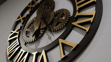 A large wall clock with Roman numerals and mechanical gears.