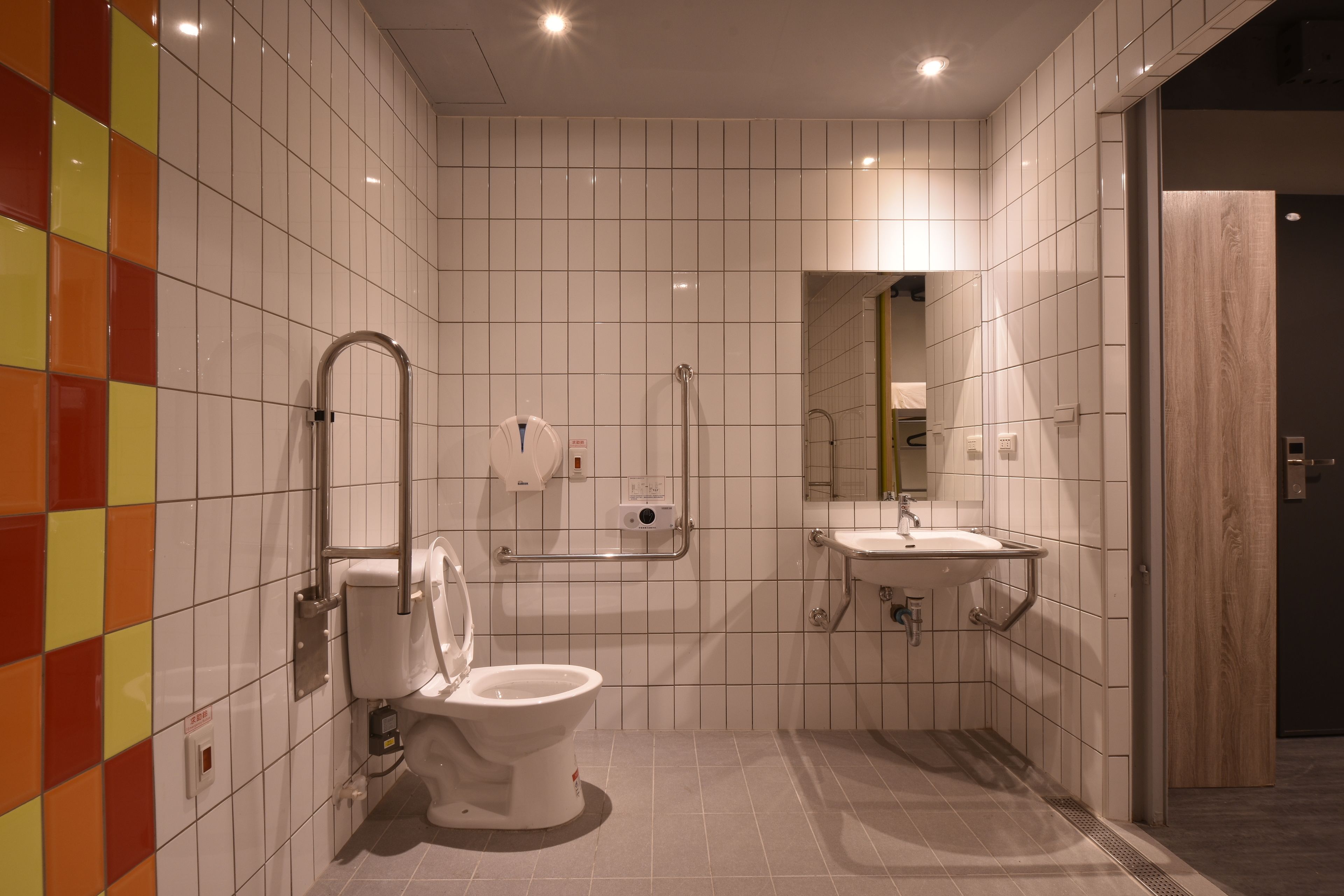 A modern bathroom with a toilet, sink, and mirror.