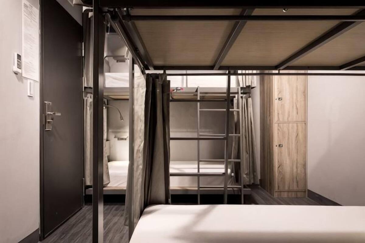 A compact room with bunk beds, a wardrobe, and a door.