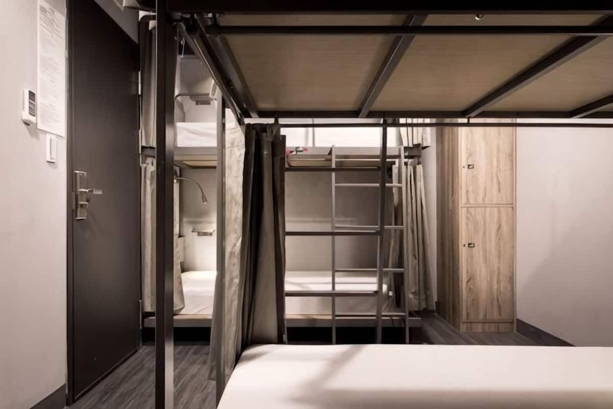 Une petite pièce avec des lits superposés, une armoire et une porte.