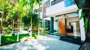 A modern building with a sign reading "The Sio Xiang Green World." - Green World Hoi An Villa (Da Nang)