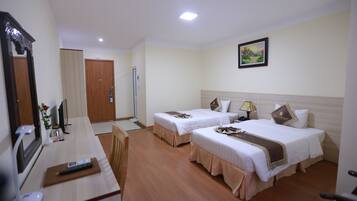 A hotel room with two beds, a desk, a chair, a mirror, a painting on the wall, and a door.