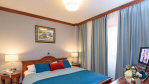 A hotel room with a large bed, two bedside tables, a TV, and a framed picture on the wall. - Villa Meri (Trogir)