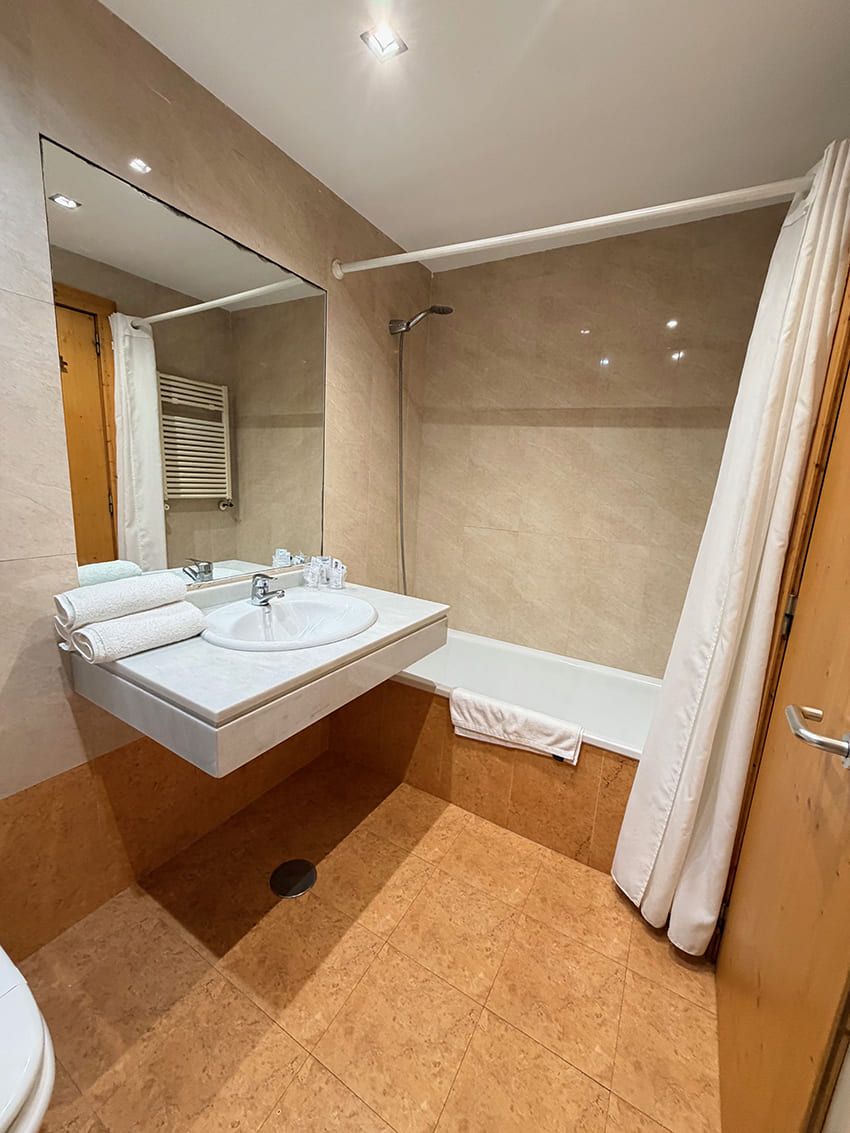 A bathroom with a sink, mirror, shower, and bathtub.