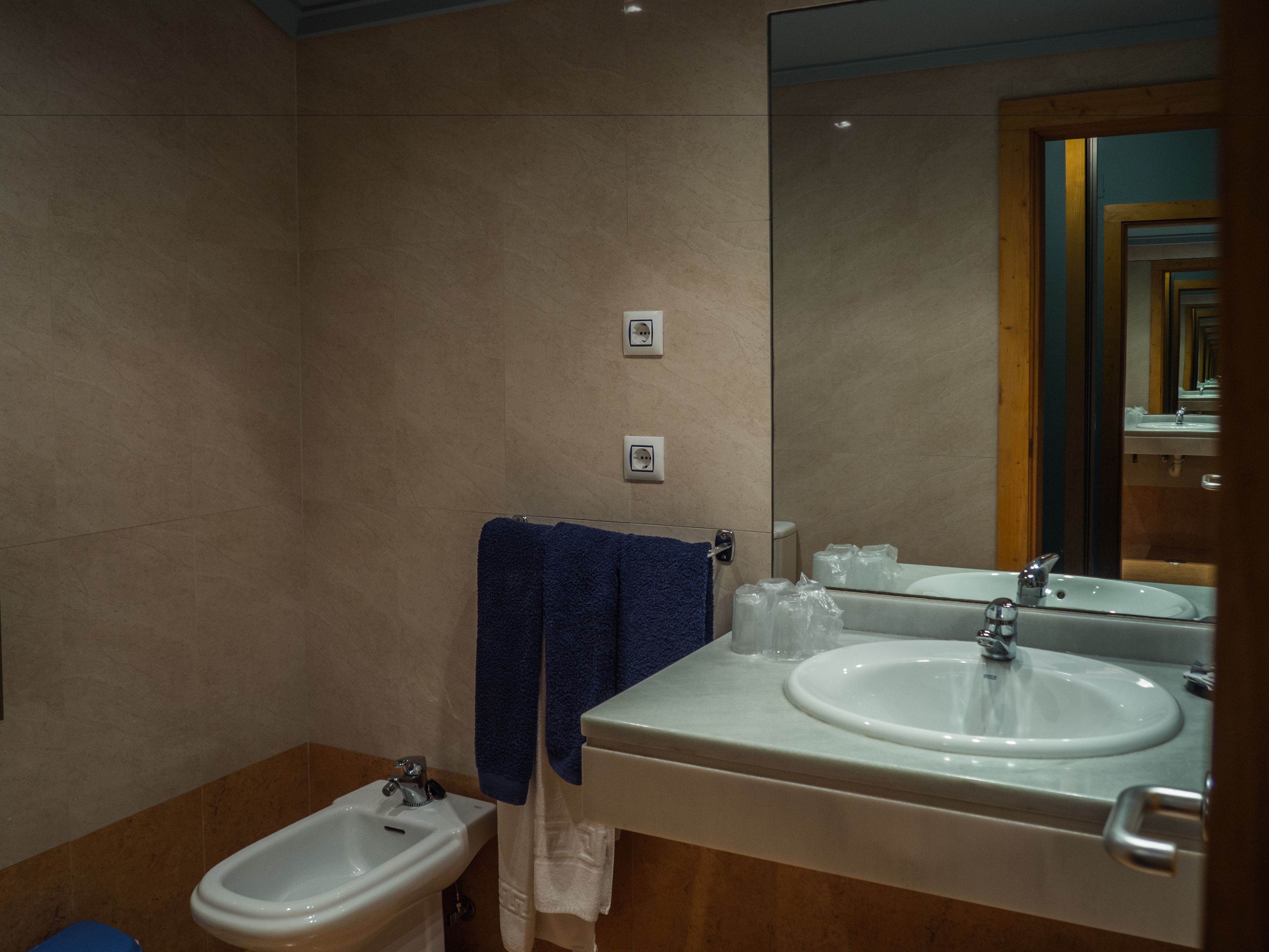 Une salle de bain moderne équipée d’un bidet, d’un lavabo et d’un miroir.