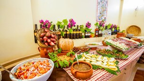 A buffet table with various food items, including a bowl of shrimp salad, a pot of beans, and an assortment of cheeses and meats. - Old River Residence (Ricadi)