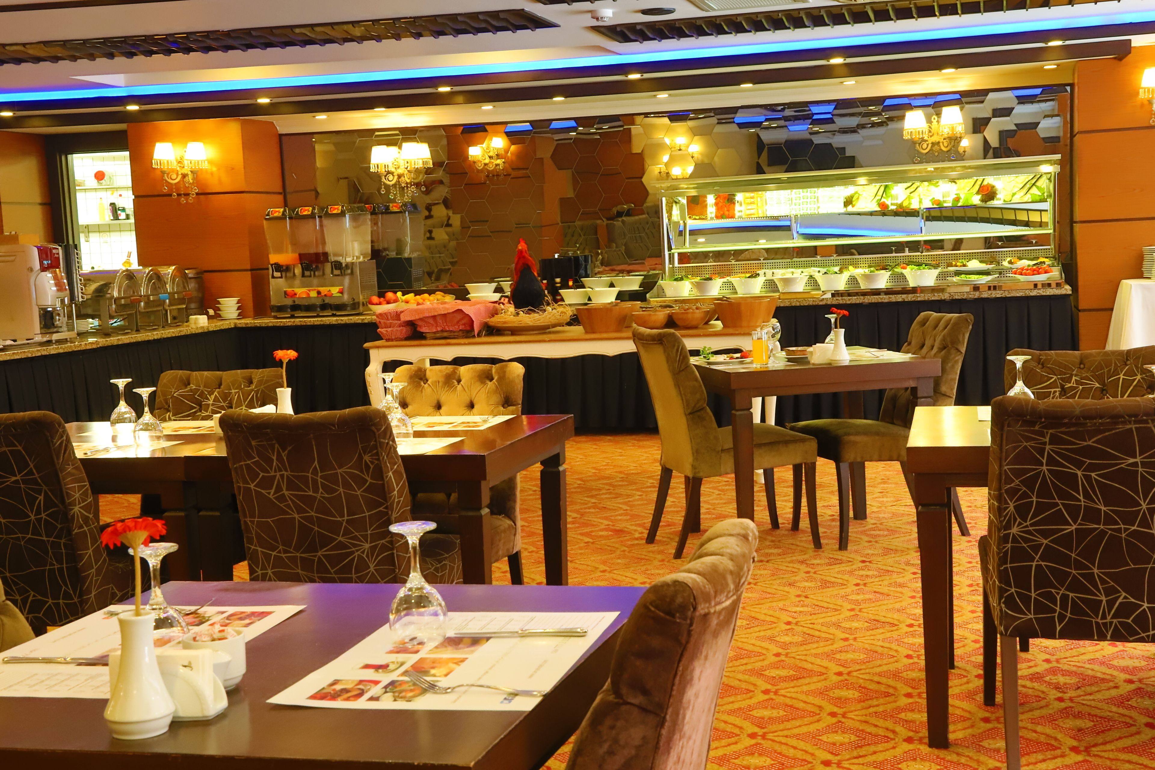 A restaurant with tables set for dining, a bar area, and a buffet.