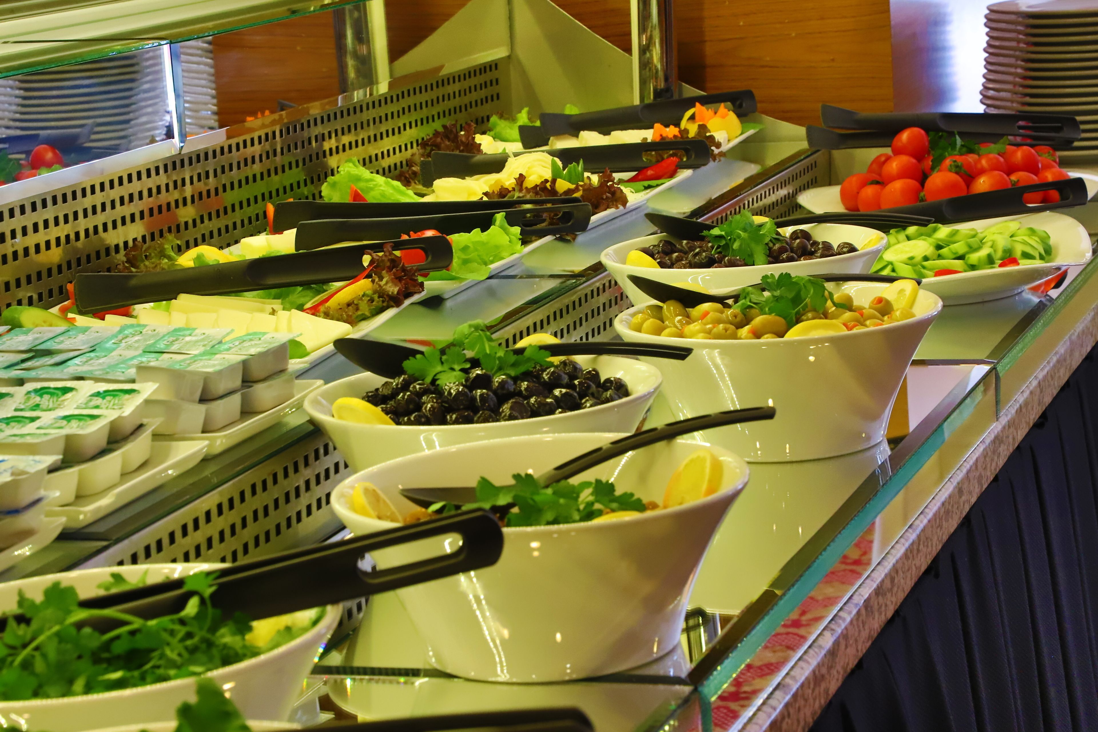 A buffet with various food items including salads, cheeses, and vegetables.