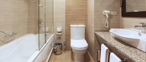 A modern bathroom with a glass-enclosed shower, a toilet, and a sink with a mirror above it.