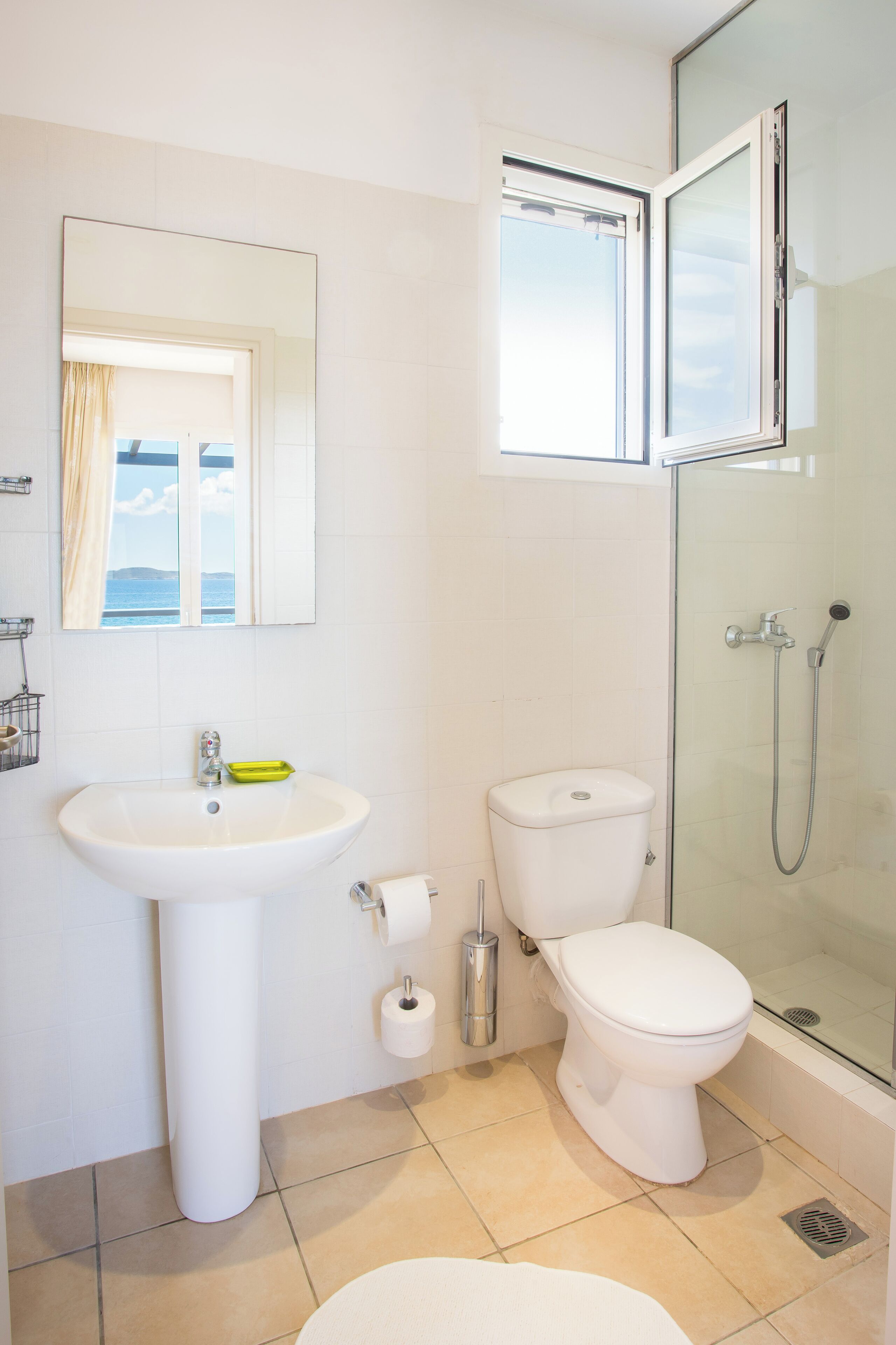 A bathroom with a sink, toilet, and glass-enclosed shower.
