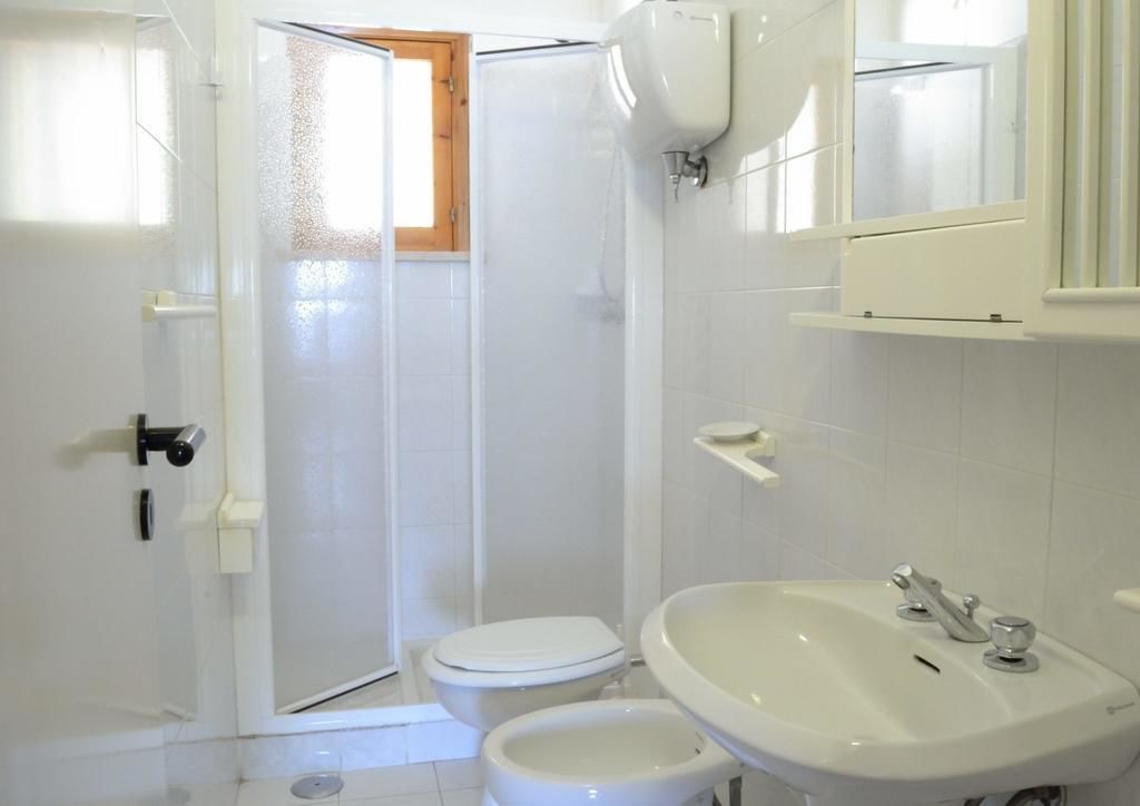 A bathroom with a toilet, bidet, and sink.