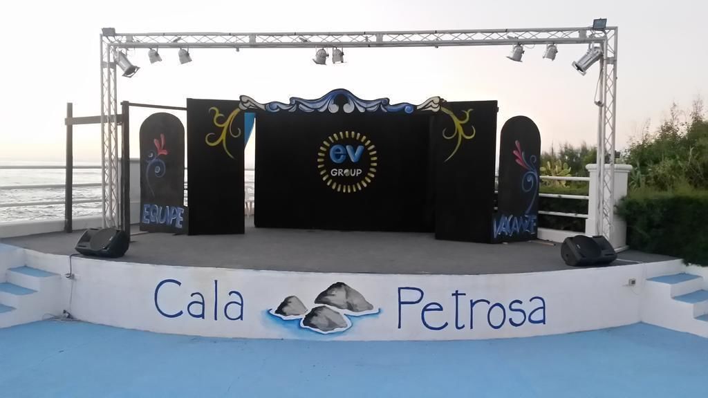 A stage with the logo 'EV GROUP' and the name 'Cala Petrosa' on the backdrop.