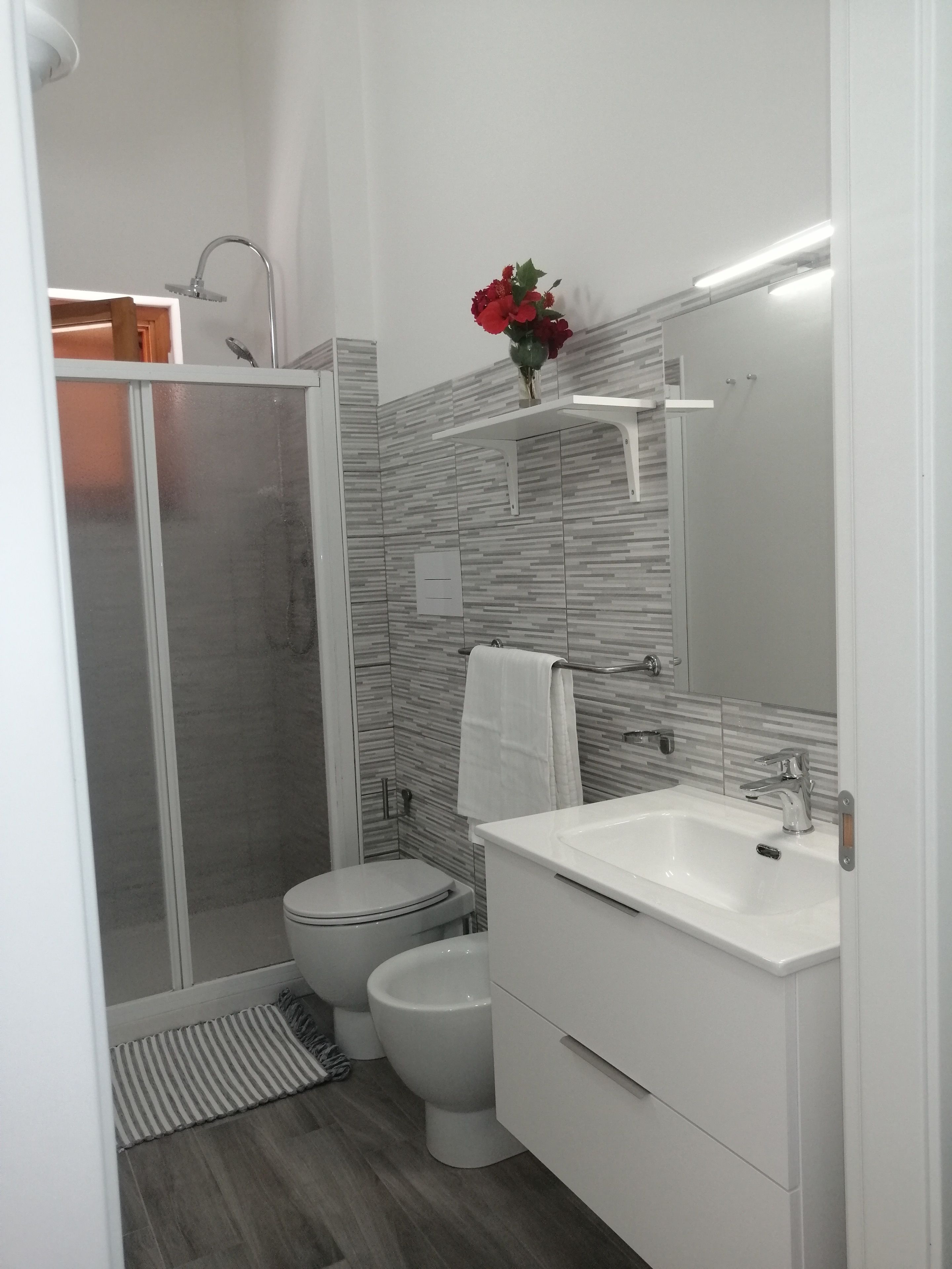 A modern bathroom with a shower, toilet, and sink.