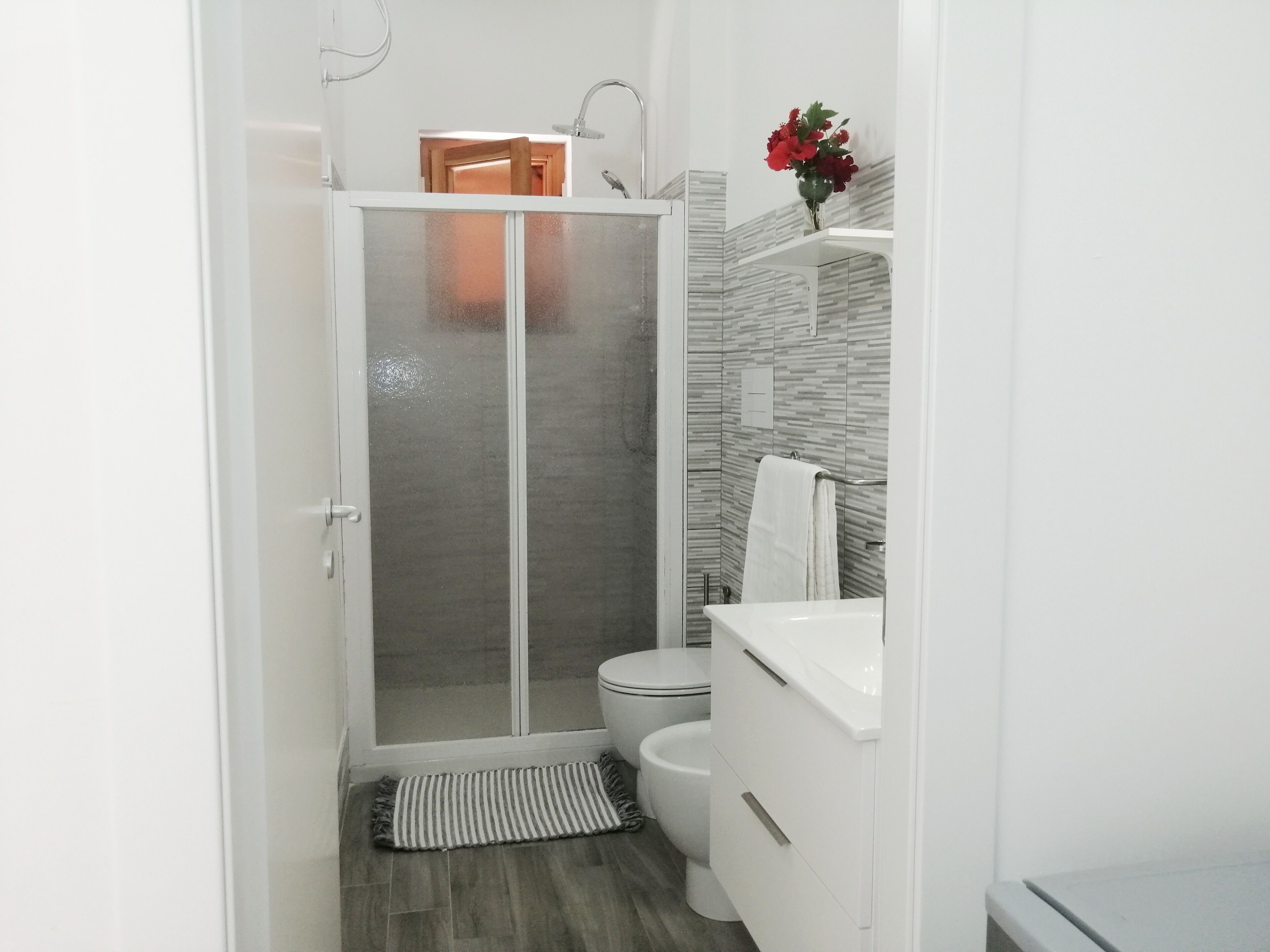 Un baño moderno con ducha envuelta en vidrio, inodoro y lavabo.