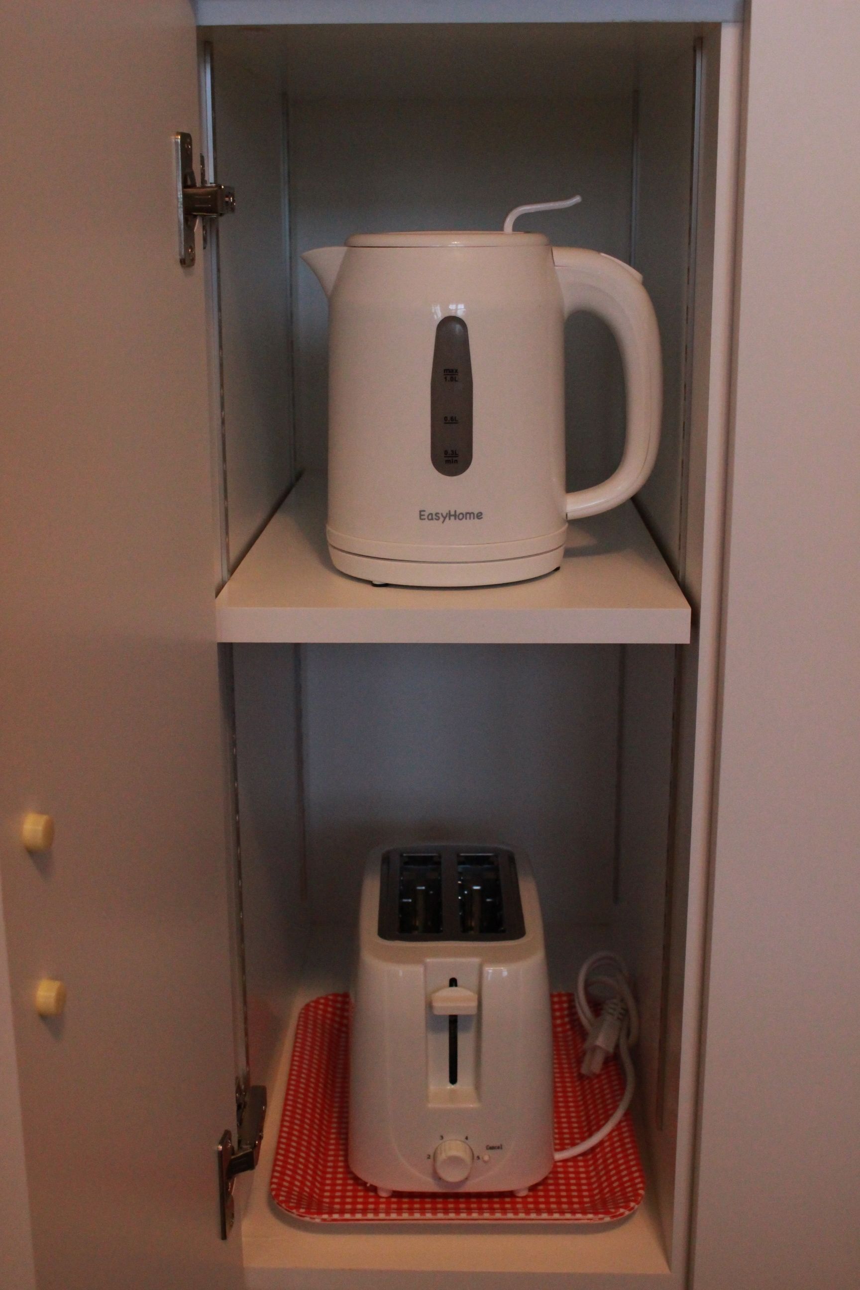 Una tetera y un tostador blancos EasyHome sobre una estantería.