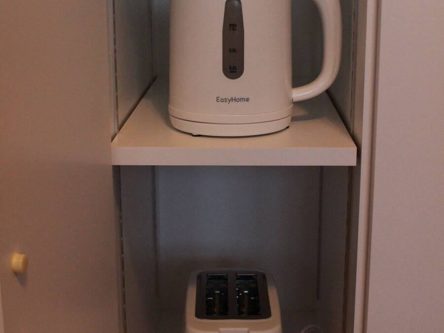 Una tetera y un tostador blancos EasyHome sobre una estantería.