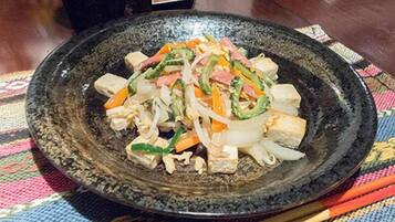 A plate of stir-fried vegetables and tofu on a textured tablecloth.