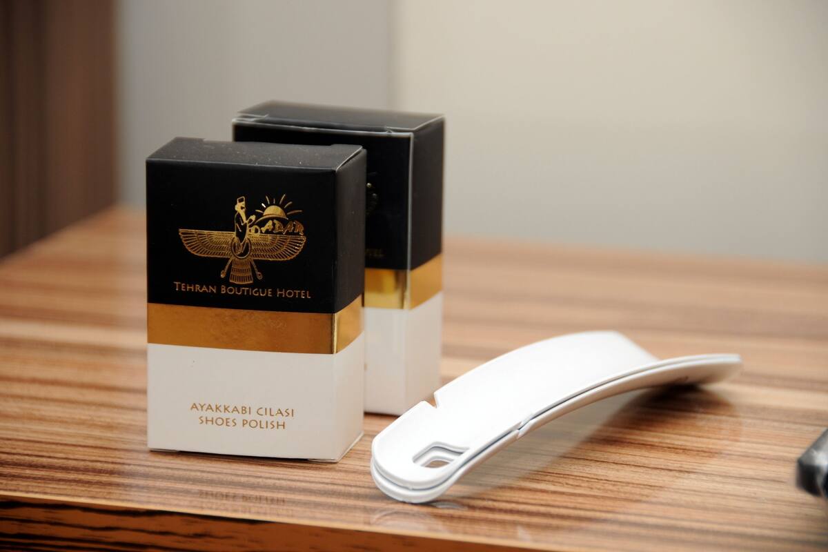 Two boxes of Ayakkabi Cilasi shoes polish on a wooden surface with a white object beside them.