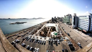 A parking lot with cars, a waterfront view, and a building labeled "Sheraton Beach Hotel".