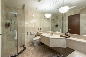 A modern bathroom with a glass-enclosed shower, a toilet, a sink with a mirror, and a wooden door. - Shangria Beach Tourist Hotel (Mokpo)