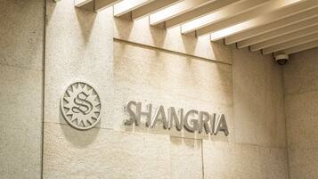 Una pared con la palabra "SHANGRIA" y un logotipo con una 'S' dentro de un círculo.