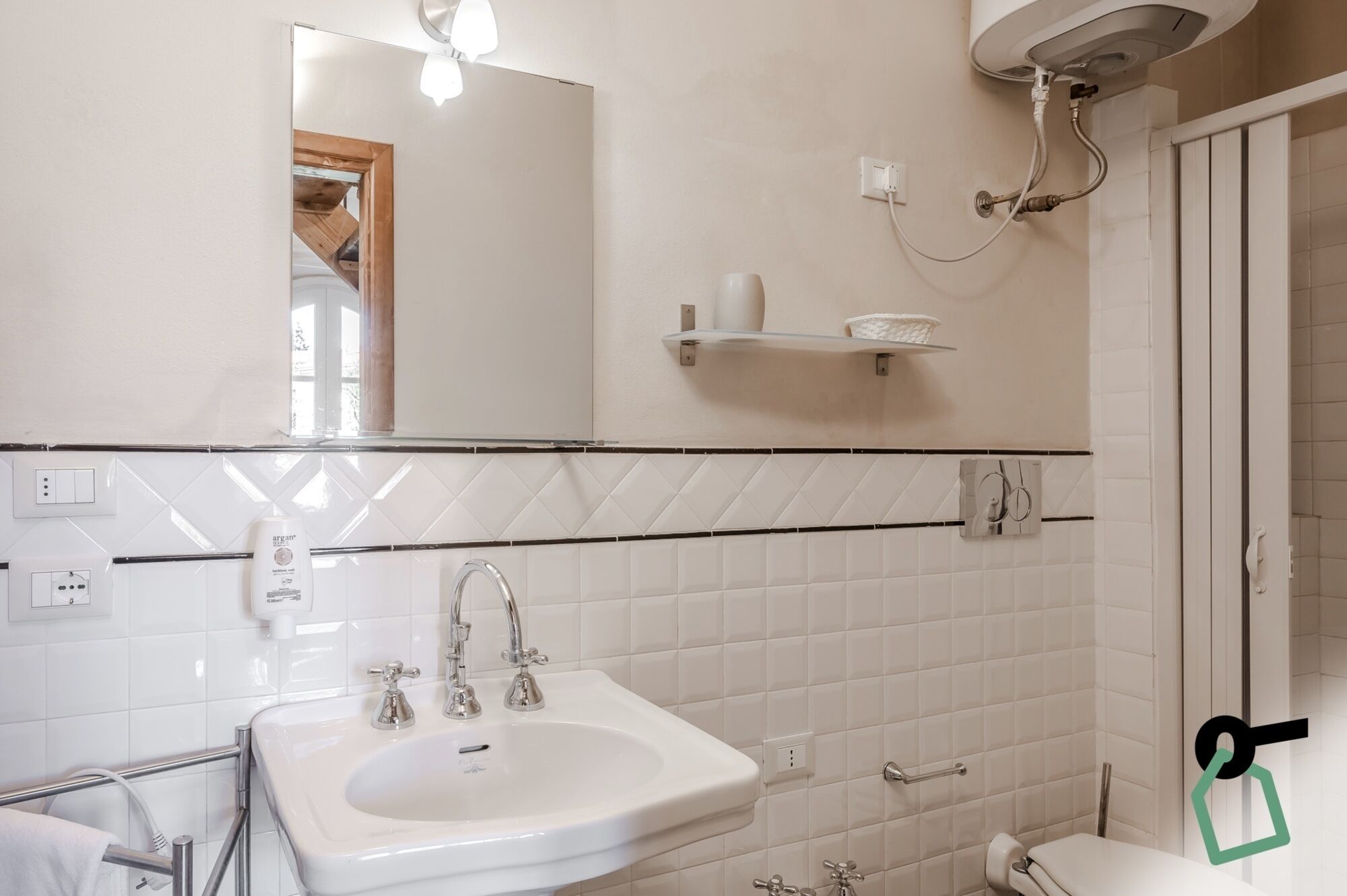 A bathroom with a sink, mirror, and shower.