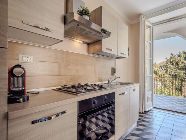 A modern kitchen with a gas stove, oven, and a view of the outdoors. - HOTIDAY Apartment Collection - Lerici Terrediliguria (Lerici)