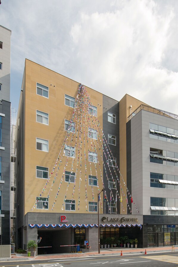 Ein Hotel mit einer markanten dreieckigen Fassade, einem Parkplatzschild und einem 'P', das freie Parkplätze anzeigt.