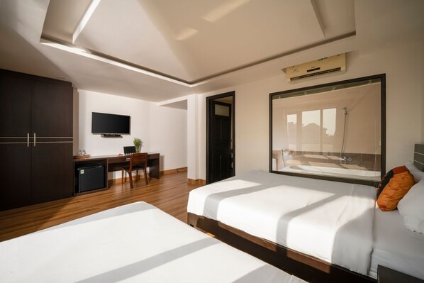 A modern hotel room with a large bed, a desk, a flat-screen TV, and a large mirror. - Stayzi Hotel (Da Nang)