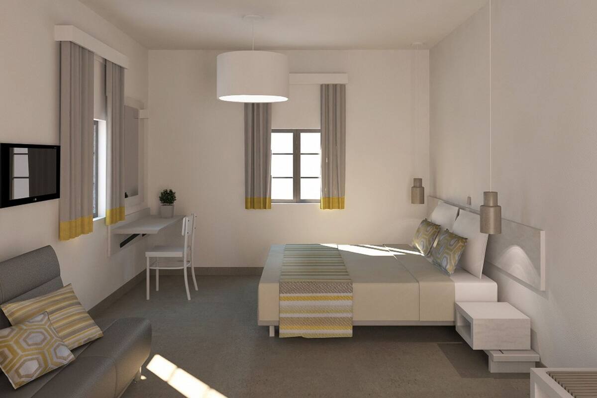 A modern bedroom with a bed, bedside tables, a desk, a chair, and a TV.