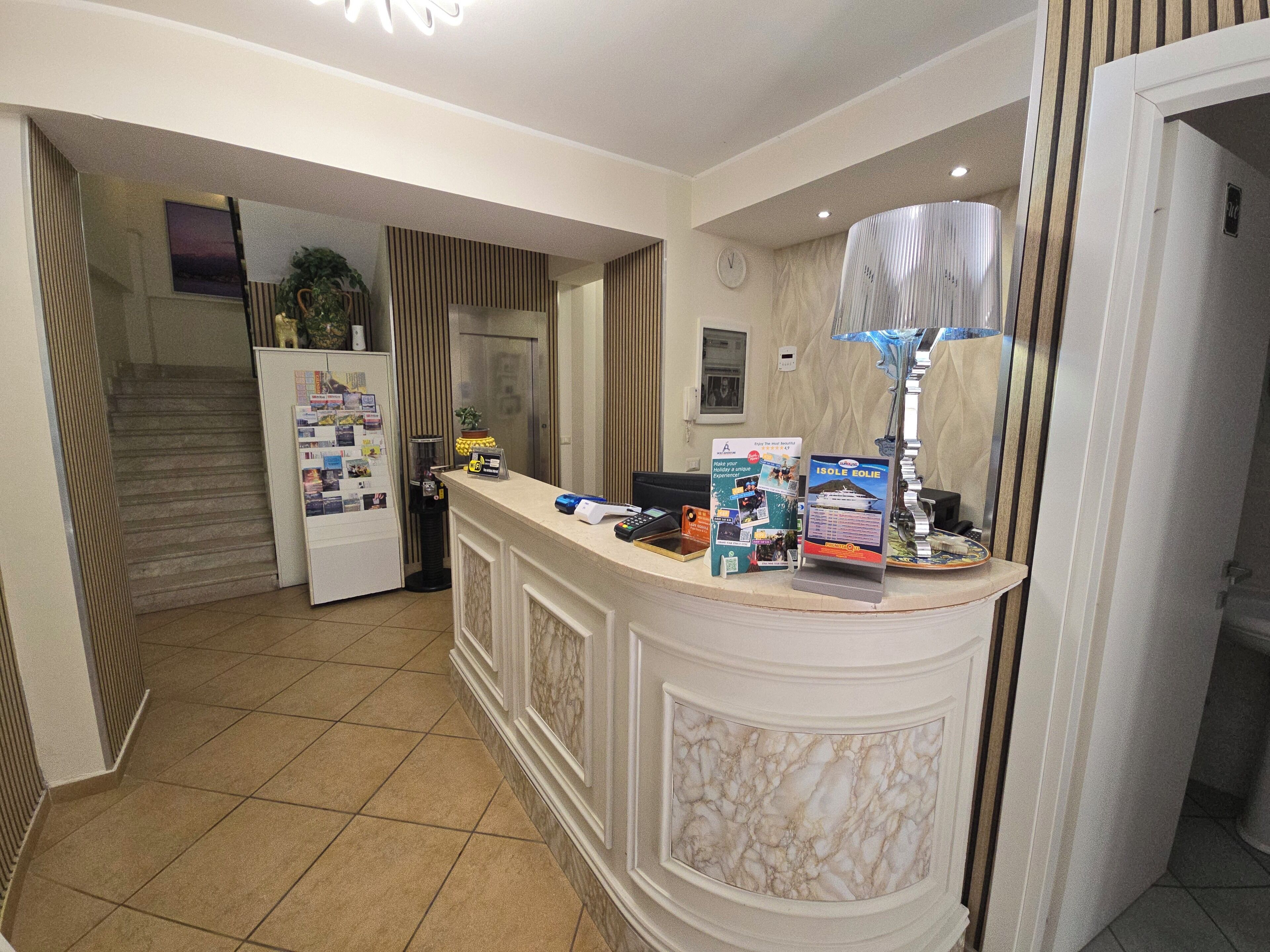 A hotel reception area with a marble counter, a clock, and a sign for an island resort.