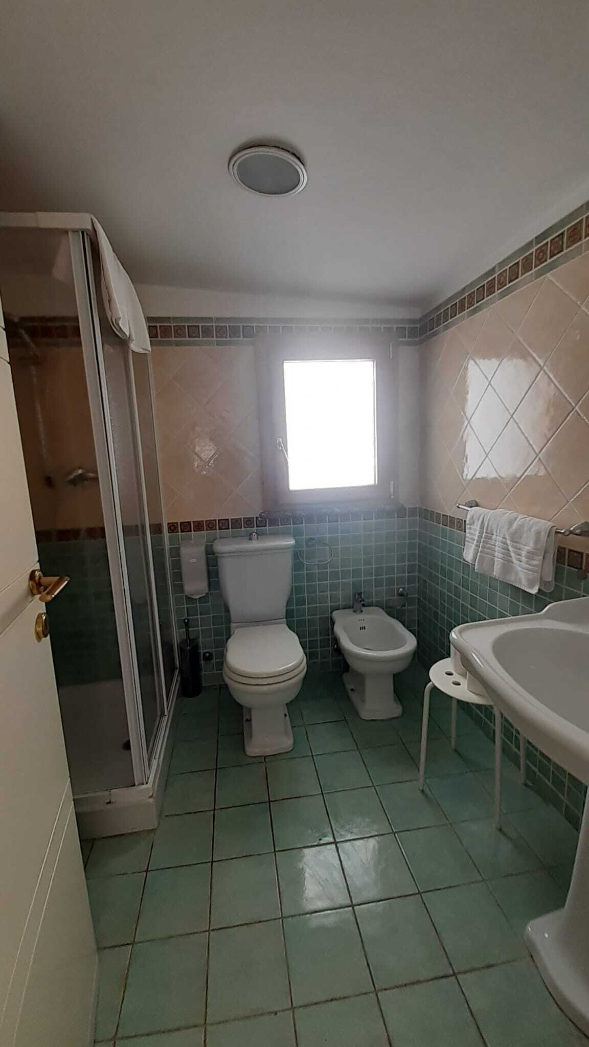 A bathroom with two toilets, a shower, and a bathtub.