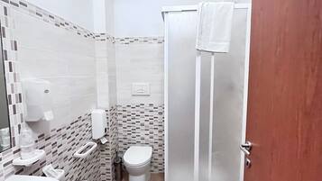 Un bagno con lavandino, WC e doccia.