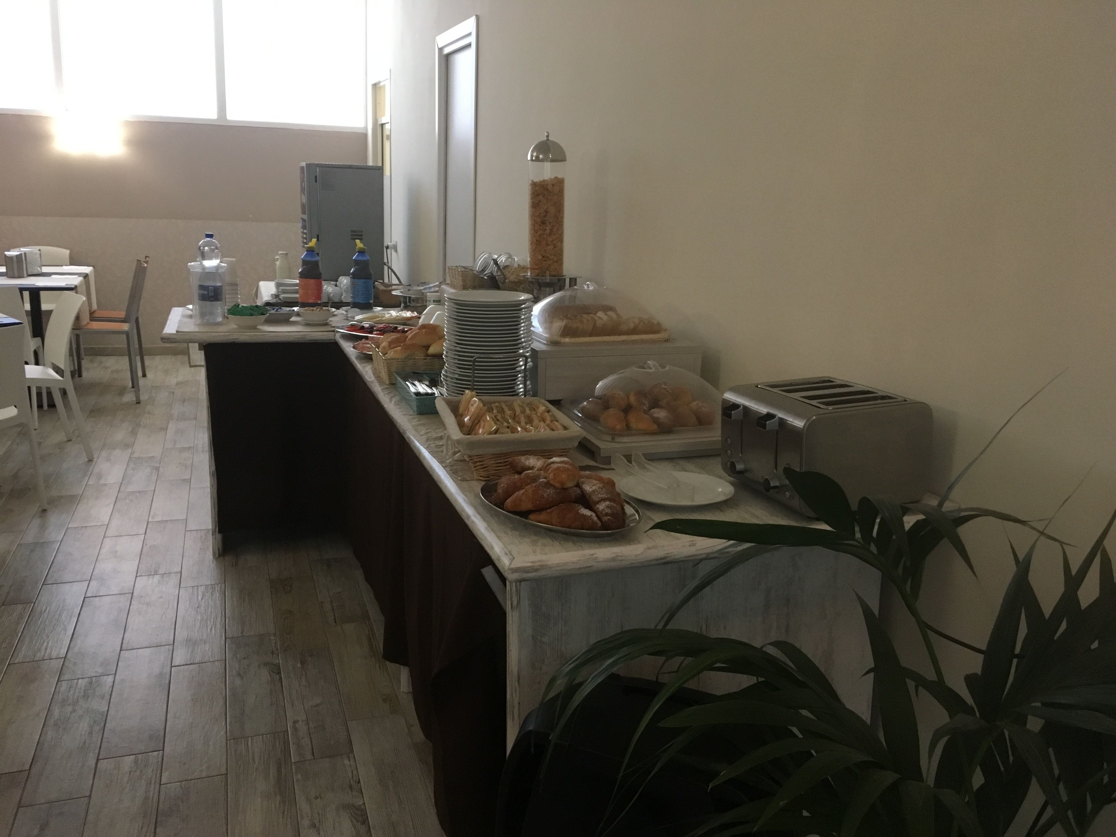 A buffet setup with various food items, a toaster, and a water dispenser.