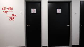 Three black doors with signage indicating room numbers 201-203 and 205, and a disabled toilet sign.