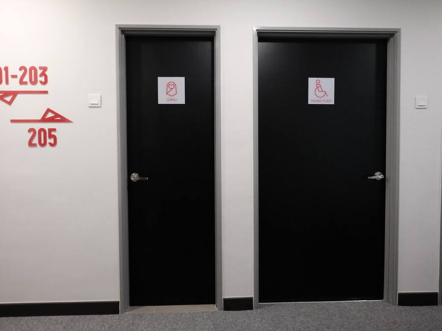 Three black doors with signage indicating room numbers 201-203 and 205, and a disabled toilet sign.