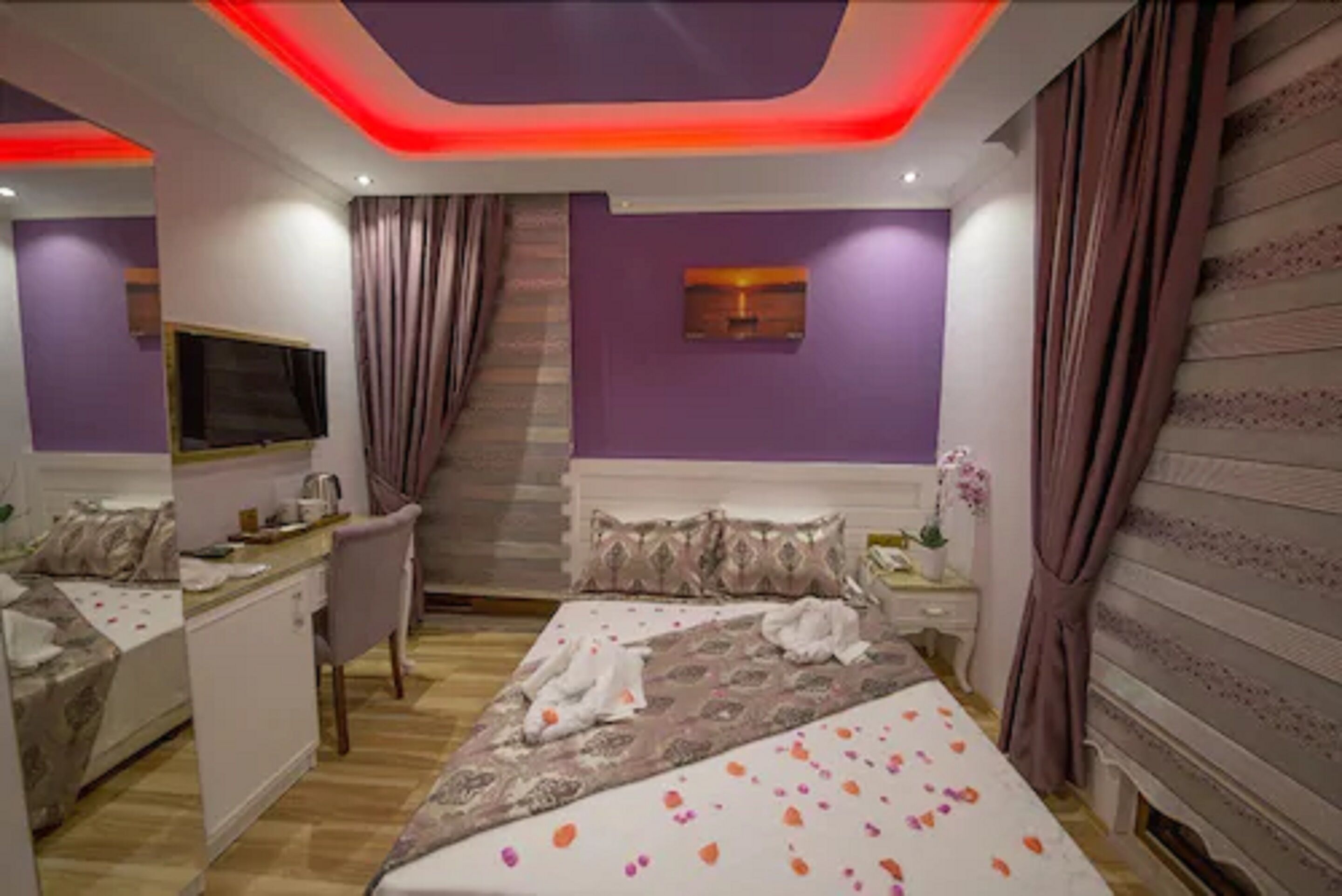 Una habitación de hotel con cama, escritorio, silla, televisor y escalera.