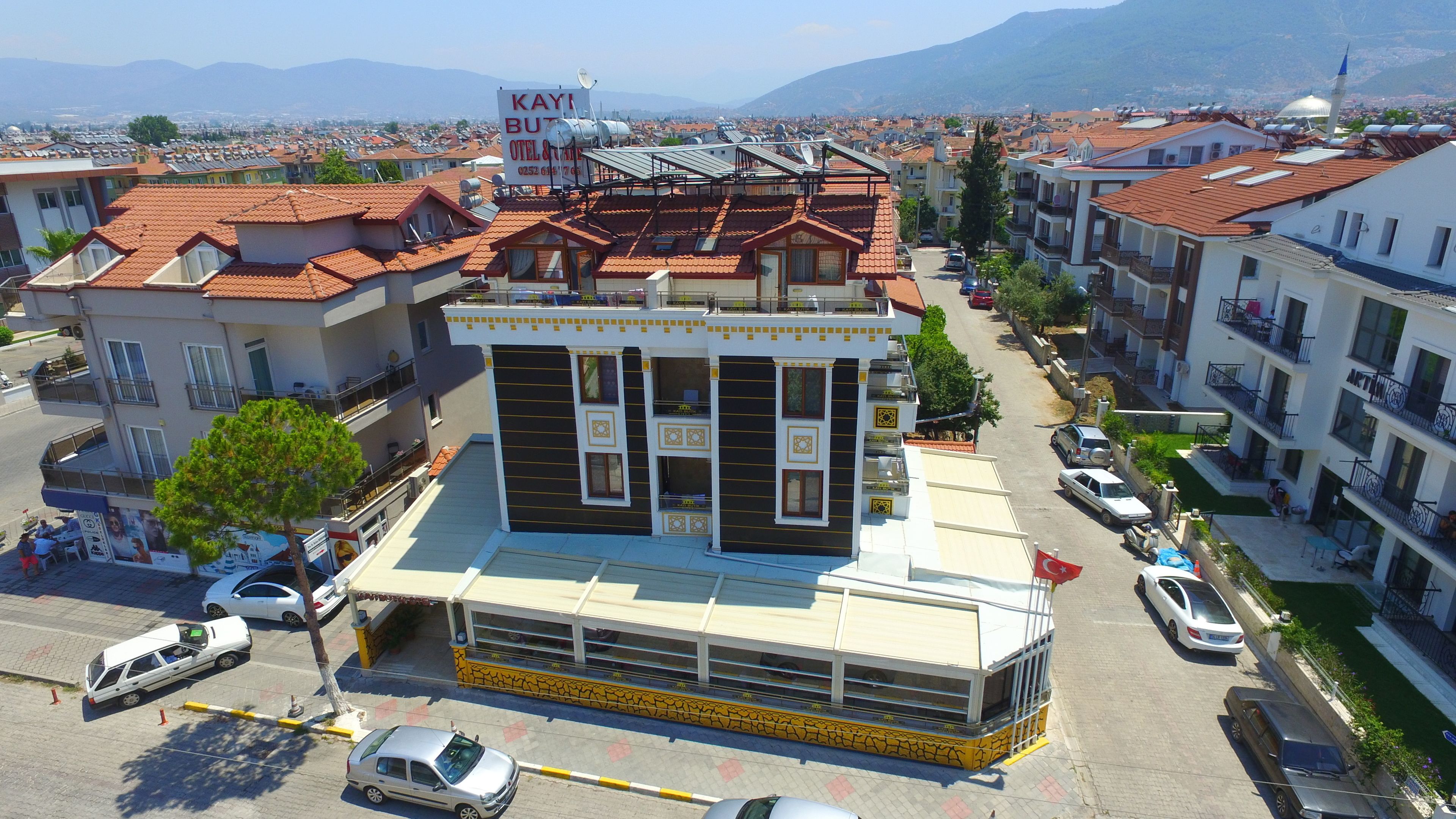 A hotel with a modern design, featuring a central courtyard, multiple balconies, and a view of the surrounding cityscape.
