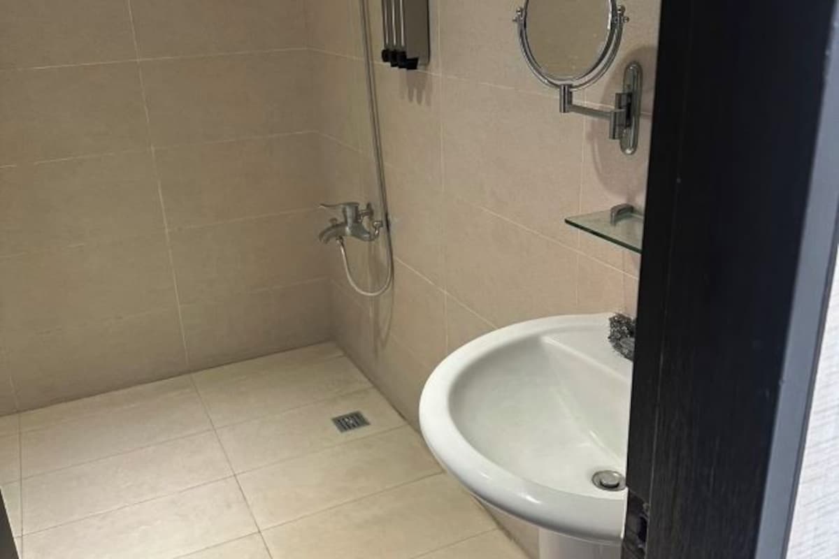 A small bathroom with a sink, a mirror, and a shower.