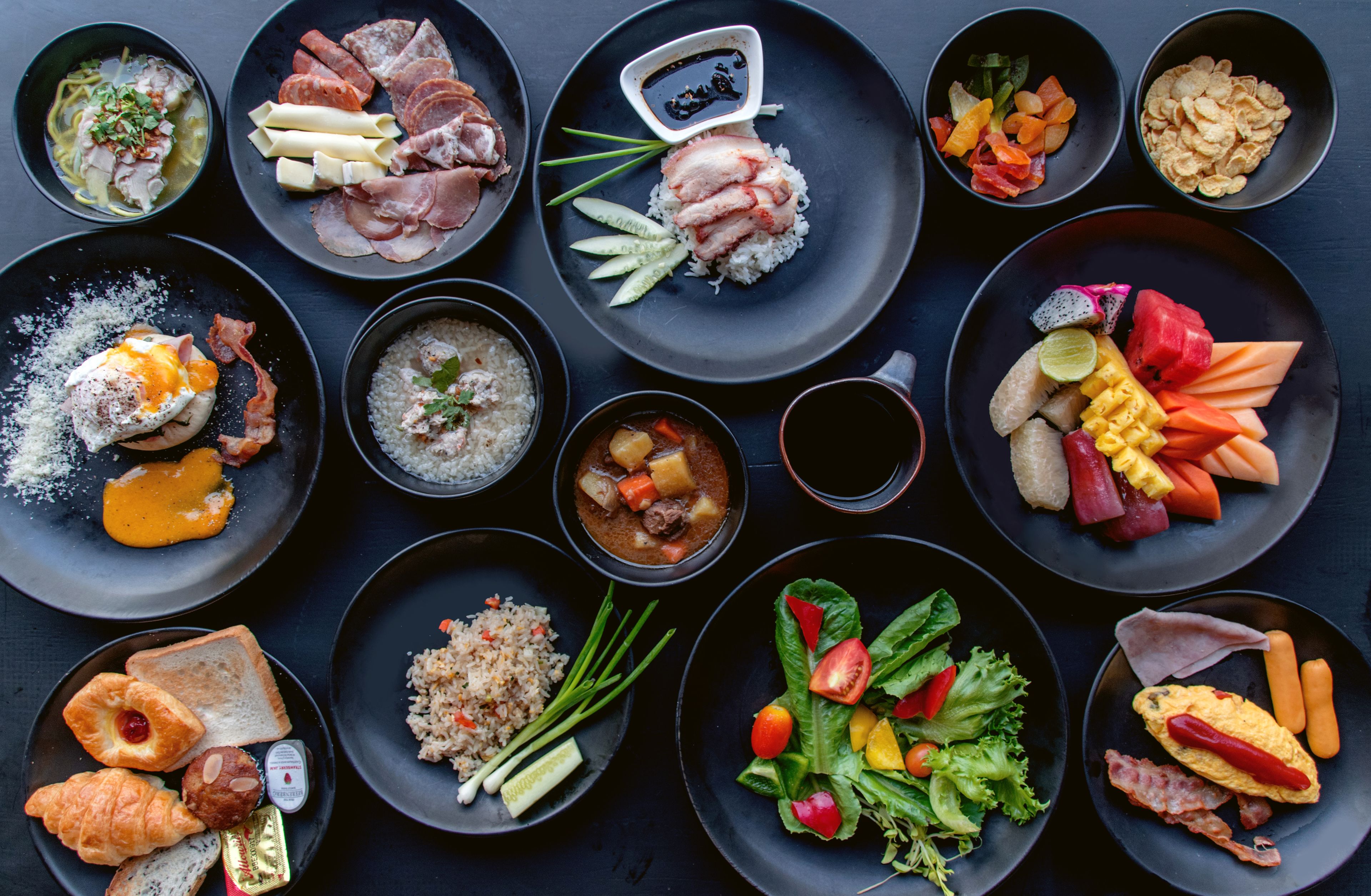 A variety of dishes arranged on multiple plates, including rice, vegetables, and meat.