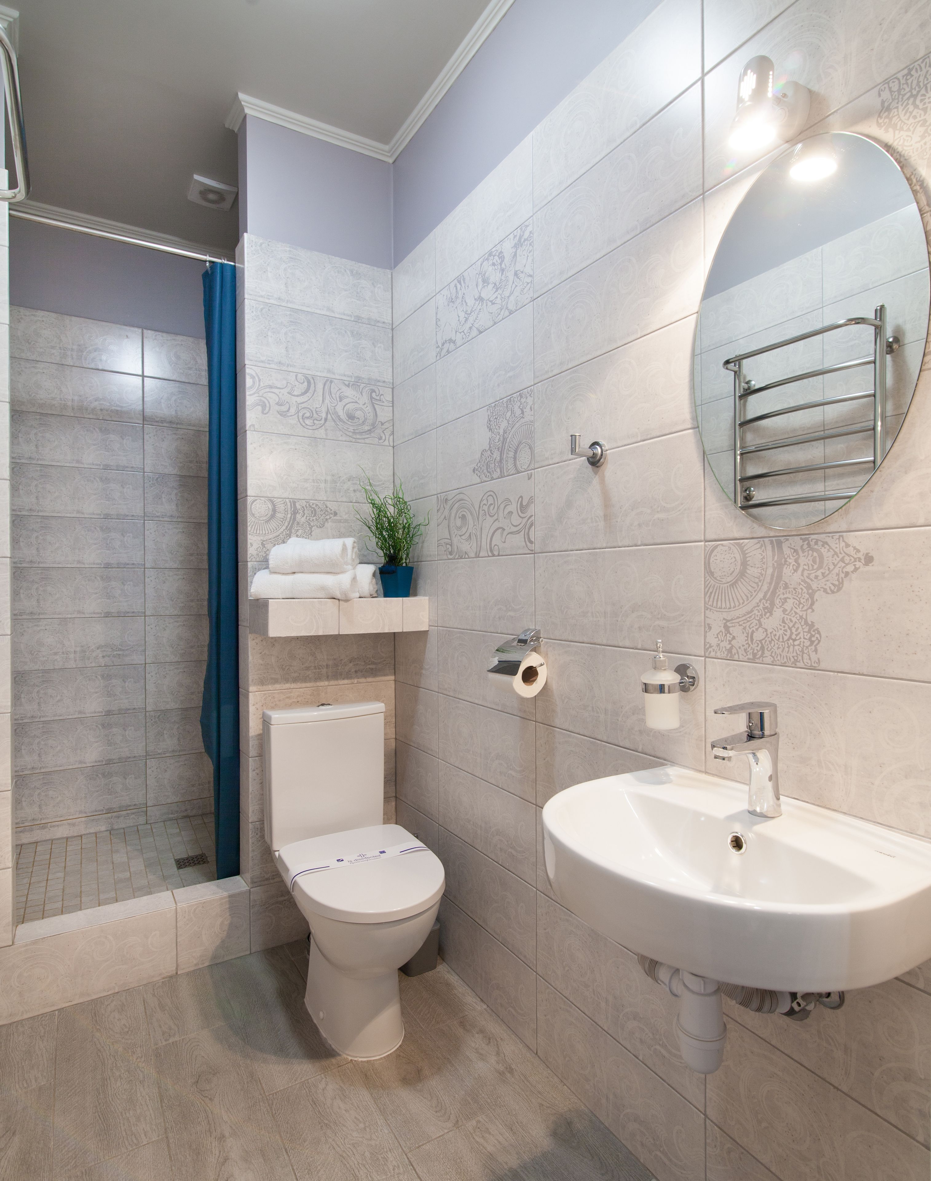 Et moderne badeværelse med toilet, vask og brusebad.