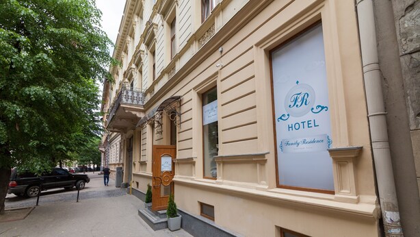 Een hotelgevel met een groot bord waarop staat 