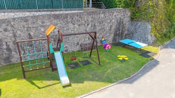 Un parque infantil con columpios, tobogán y estructura para escalar.