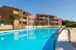 Una piscina al aire libre, sillones reclinables de piscina