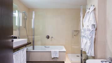 Ein modernes Badezimmer mit einer Duschkabine, einer freistehenden Badewanne und einem Waschbecken auf Säule.