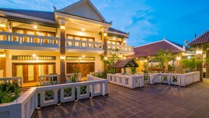 A large, multi-story hotel with a traditional architectural style, featuring balconies and a spacious courtyard with seating areas. - Amour d'Angkor (Siem Reap)