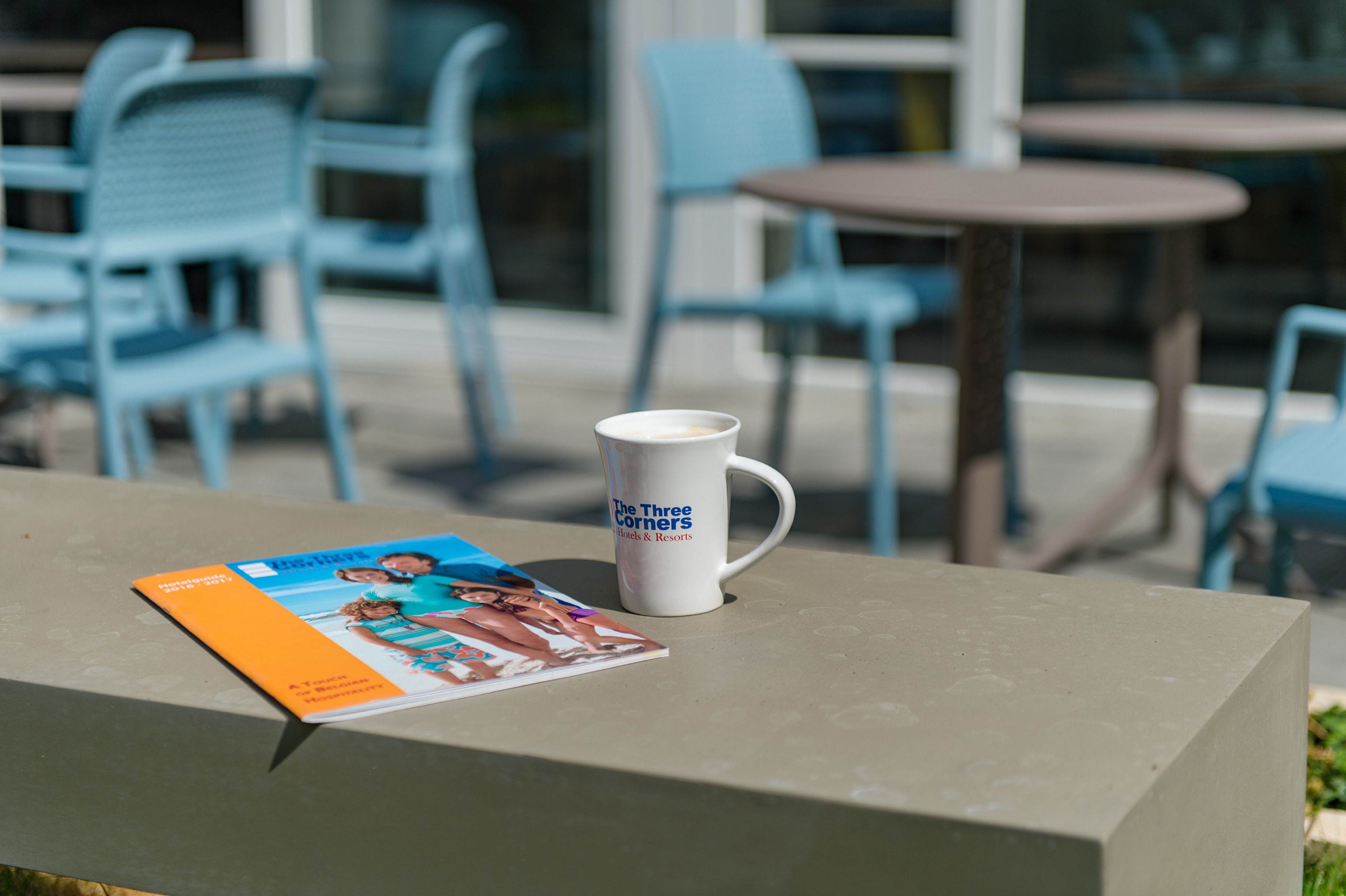 A table with a magazine and a mug on it.