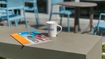 A table with a magazine and a mug on it.