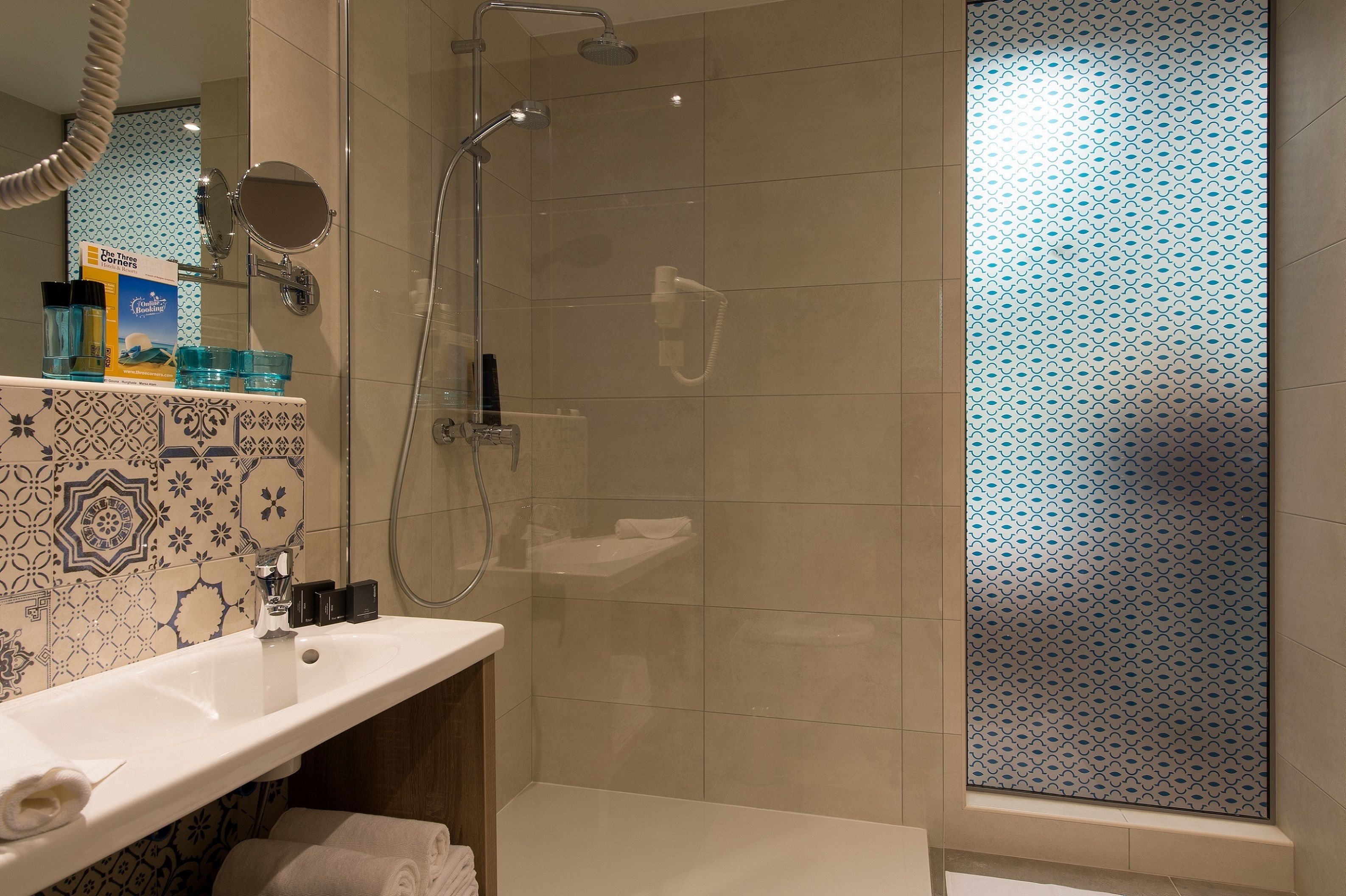 A modern bathroom with a shower, a sink, and a mirror.